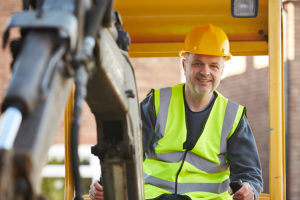 Male Construction Worker Operating Digger On Site; short vs long term contractor equipment rental